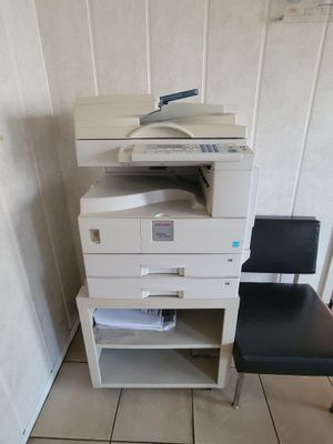 a printer and a chair in the corner of a room