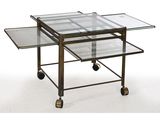 une table basse en verre et laiton, montée sur roulettes, avec un plateau en verre