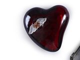 a heart shaped glass object with a butterfly on it