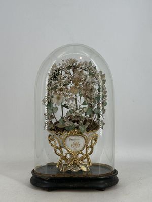 un dôme de verre avec une horloge à l'intérieur sur une table