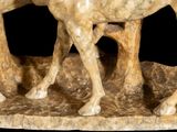 a statue of two horses that are standing on a rock