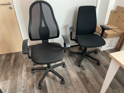 deux chaises de bureau noires posées l'une à côté de l'autre sur le sol