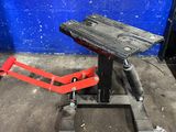 a wooden bench sitting on top of a metal stand in front of a blue wall