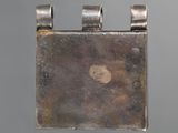 a close up of a silver pendant with a bird on it
