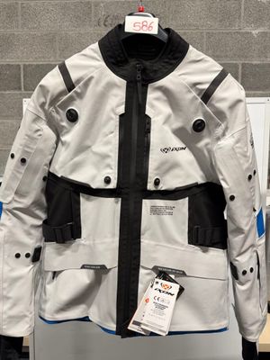 une veste blanche rehaussée de touches noires et bleues, exposée