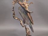 a statue of a bird sitting on a branch with a bird on it ' s back
