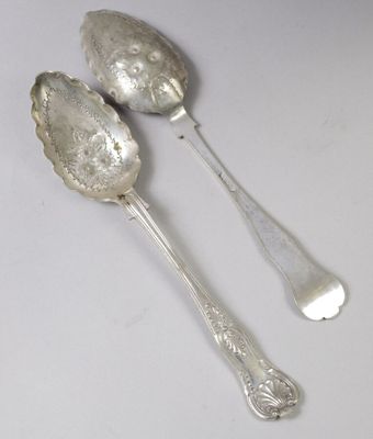 une paire de cuillères en argent posées sur une table blanche