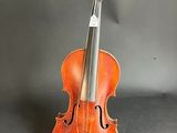 an old violin sits on a stand against a gray background