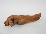 a wooden animal that is laying down on the ground