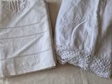 two white napkins on a bed with white sheets