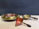 two brass serving dishes and a spoon on a wooden table