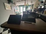 deux ordinateurs portables posés sur une table dans un restaurant
