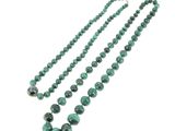 un gros plan d'un collier de perles vertes sur fond blanc