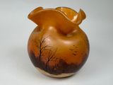 a vase with a painting on it sitting on a table