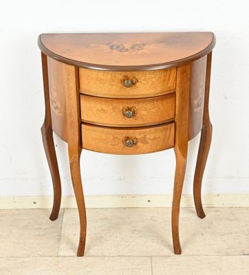 a small wooden table with three drawers on it