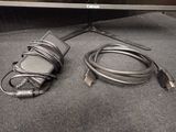 a computer monitor and a charger sitting on the floor