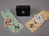 three playing cards and a box on the table