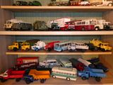 de nombreuses petites voitures et camions sur une étagère dans une pièce
