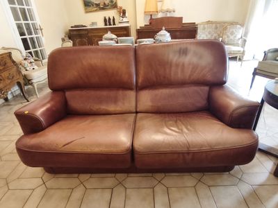 a brown leather couch sitting in a living room