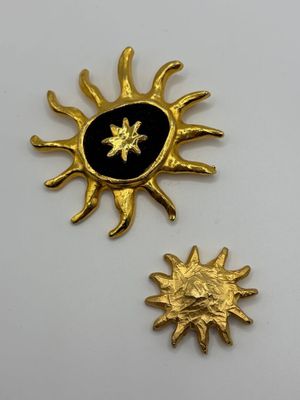 two gold and black enamel sun and star brooches
