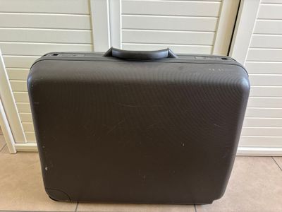 une valise noire posée par terre devant une porte