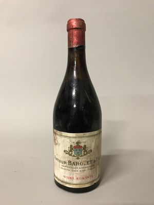 une vieille bouteille de vin posée sur une table blanche