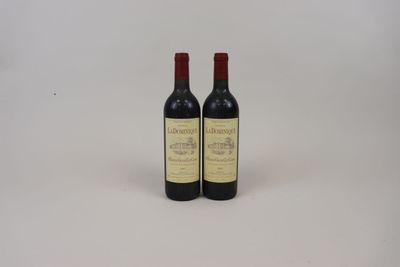 deux bouteilles de vin posées sur une table l'une à côté de l'autre