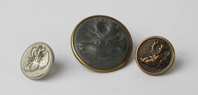 a close up of a coin and a button on a white surface