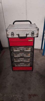 une boîte à outils rouge posée sur un chariot métallique