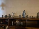 a shelf with cups and vases on top of it