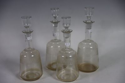 trois bouteilles en verre transparent sont alignées sur une surface blanche