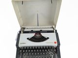 an old typewriter with a case on top of it