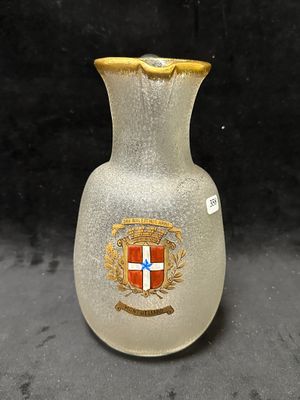 un vase en verre orné d'un blason