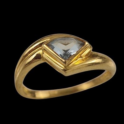 une image d'une bague en or avec une pierre en topaze bleue