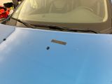 a blue car that is parked in a parking lot