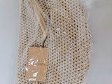 a mesh bag with a tag on it on a table