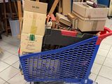 un caddie bleu rempli de cartons au milieu d'une pièce