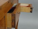 a wooden desk with a drawer on top of it
