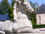 a statue of a horse that is laying down on the ground