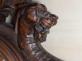 a wooden clock with a lion head on it