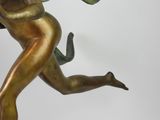 bronze statue of a woman running with her arms outstretched