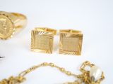 a lot of gold jewelry on a white surface