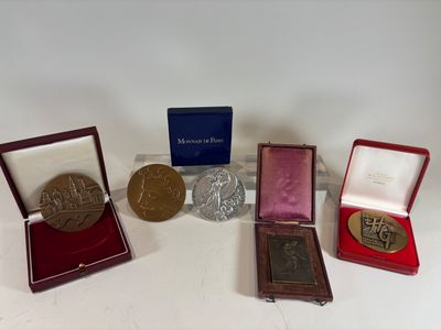 four medals and a medal are sitting on a white surface