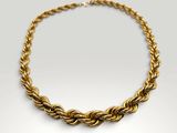 a gold necklace with a twisted rope on a white background