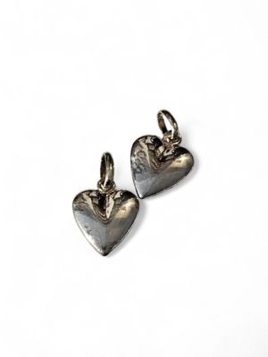 a pair of silver heart charms on a white background