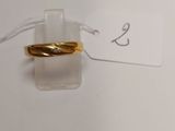 a gold ring on top of a clear piece of paper
