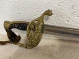 a sword that is laying on the floor next to a wall