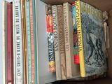 many books in a box that are stacked on top of each other