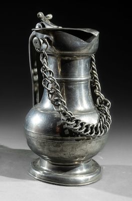 a silver vase with a chain around it on a table