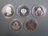 four different coins are in a plastic container on a table